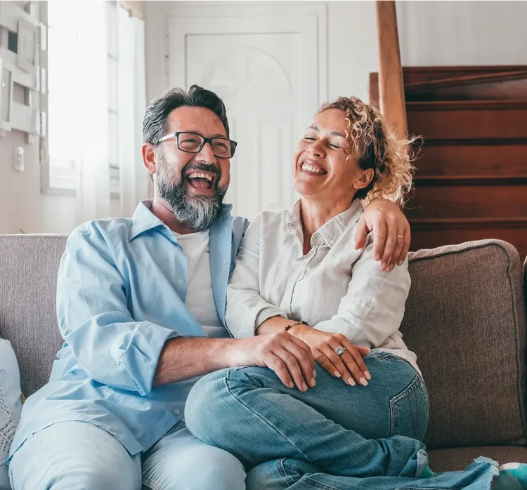 Paar lachend auf einer Couch